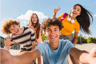 Gruppe junger Menschen macht draußen gemeinsam ein Selfie